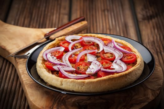 Homemade onion quiche with tomatoes and fresh onion