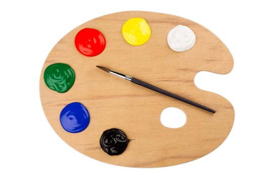 Wooden color palette with paint and brush.