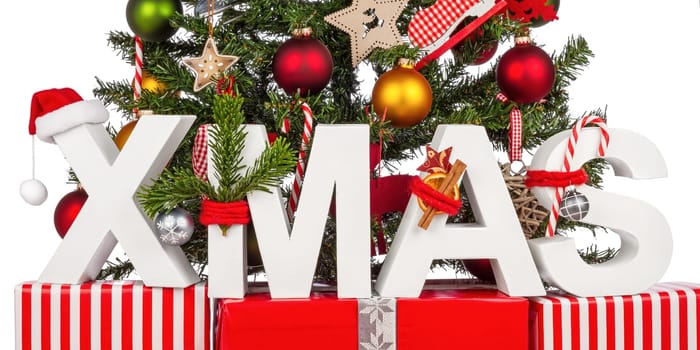 XMAS lettering on gifts in front of Christmas tree