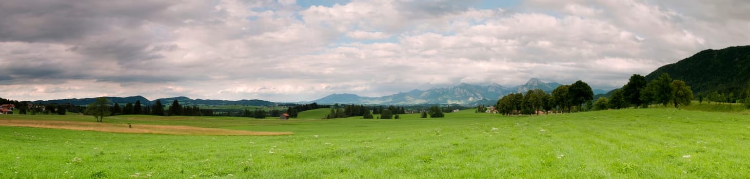 Panoramic picture in the Allgäu / Bavaria with overcast skies in summer  panoramic composed from multiple images