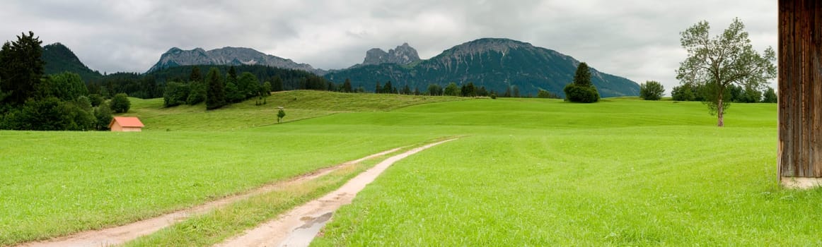 Panoramic picture in the Allgäu / Bavaria with overcast skies in summer  panoramic composed from multiple images