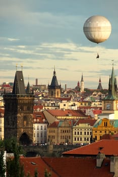 Picturesque and romantic view over the oldtown and the charles bridge of Prague having a balloon in the late afternoon sky. Soft colors.