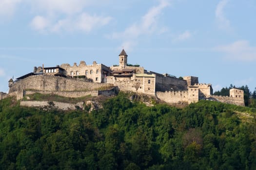 The old medieval castle of Landskron in Villach/Austria located on top of a hill surrounded by a forest.