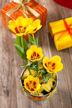 It is red yellow tulips and gift boxes, a close up