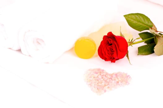 Romantic spa concept with bath salt, soaps, towels and a red rose