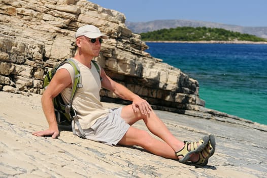 Outdoor man resting on rock after hiking, Croatia