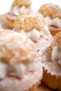 A group of fresh cakes with cream on wooden board