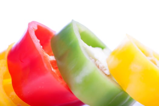 Red Yellow and Green peppers sliced on an isolated white background