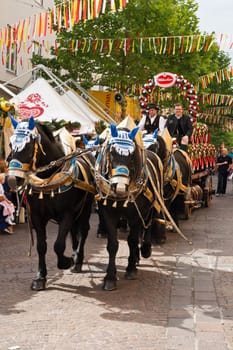 VILLACH,AUSTRIA - AUGUST 6: A traditional beerwagon being pulled by a team of horses enters the city. Photo taken at the 'Villacher Kirchtag',the largest traditional folk festival in Austria,August 6,2011 in Villach,Austria.