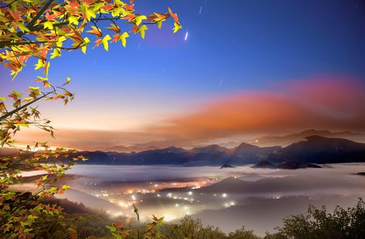 The sun setting over mountains with nice maple