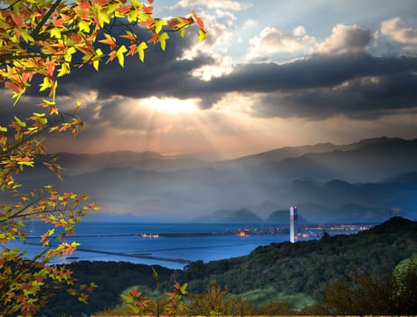 The sun setting over mountains with nice maple