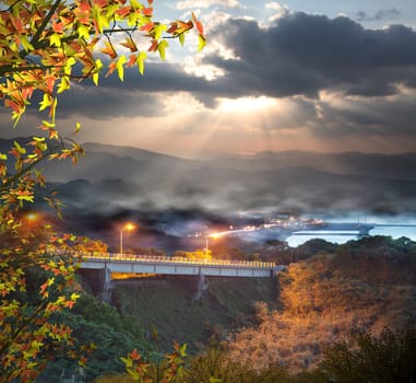 The sun setting over mountains with nice maple