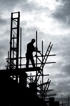 silhouette of construction worker on scaffold
