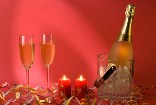 champagne with two glasses and candles on red background