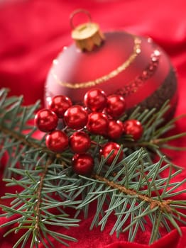 decorated pine branch on red background close up