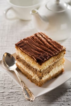 Tiramisu cake on white plate close up shoot