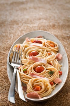 Fresh spaghetti with prosciutto and tomato sauce close up