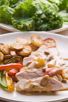 Fresh sliced chicken with roasted potato and pepper close up
