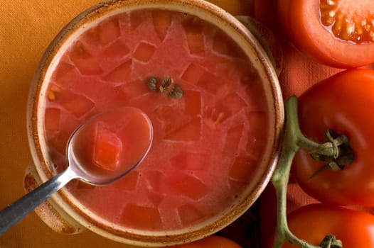 tomato soup with tomatoes in background close up