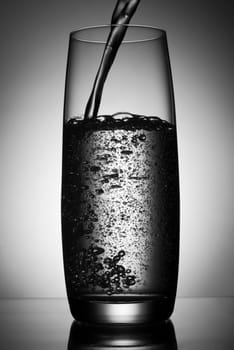 mineral water pouring into glass close up