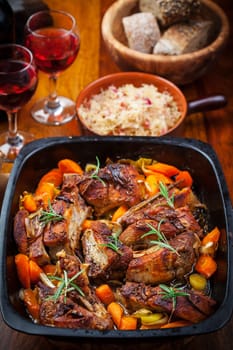 Roasted pork belly on vegetables with sauerkraut and red wine
