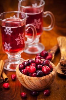 Cranberries in wooden bowl with hot mulled wine