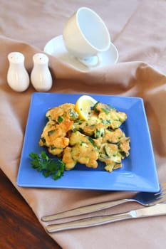 Delicious and delicate freshly fried courgette fritters with parsley ready to serve.