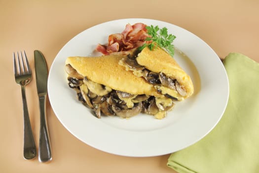 Delicious mushroom omelette with cheese, bacon and parsley ready to serve for breakfast.