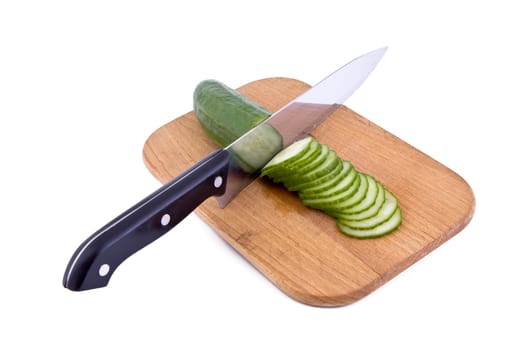 Fresh green cucumber with a kitchen knife and cutting board