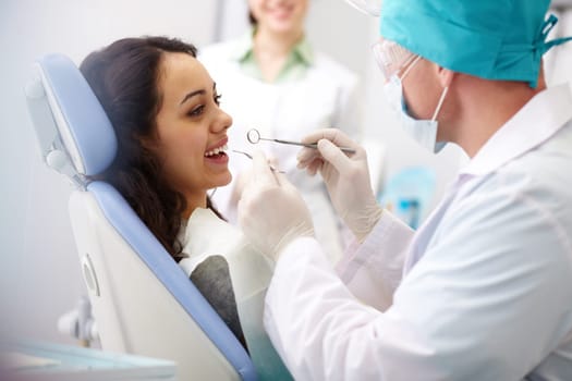 Pretty girl sitting at the dentists and having mouth checkup