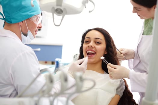 Pretty girl sitting at the dentists and having mouth checkup