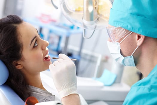 Pretty girl having mouth checkup in hospital