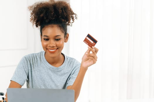 Young happy woman buy product by online shopping at home while ordering items from the internet with credit card online payment system protected by crucial cyber security from online store platform