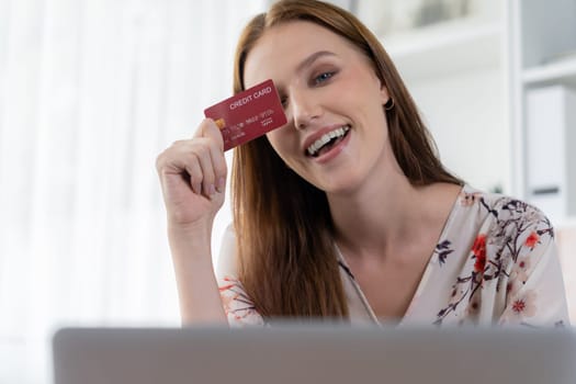 Young happy woman buy product by online shopping at home while ordering items from the internet with credit card online payment system protected by utmost cyber security from online store platform