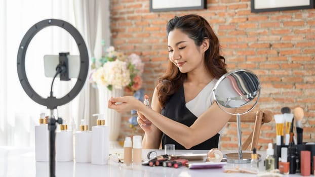 Woman influencer shoot live streaming vlog video review makeup uttermost social media or blog. Happy young girl with cosmetics studio lighting for marketing recording session broadcasting online.