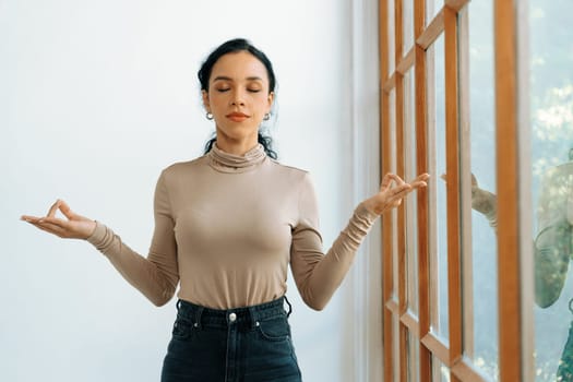 Young African American woman practice crucial mindful meditation at home living room for improving mental health strength and peaceful beautiful living