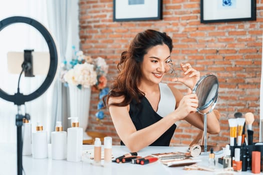 Woman influencer shoot live streaming vlog video review makeup uttermost social media or blog. Happy young girl with cosmetics studio lighting for marketing recording session broadcasting online.