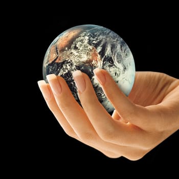 Side view of a woman's hand holding the earth on a black background.