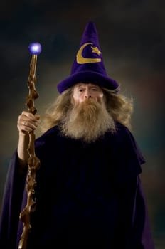 Image of a man dressed as a wizard holding a glowing staff.