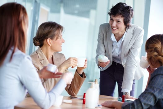 Image of four businesswomen talking about beauty products at break