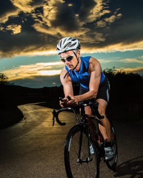 Triathlete on the bike in sunset
