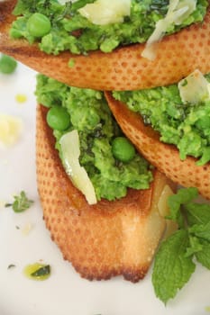 Delicious green pea baguettes with shaved cheese and mint with avocado oil.
