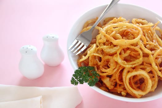 Delicious crispy onion rings fried in batter with tartare sauce ready to serve.