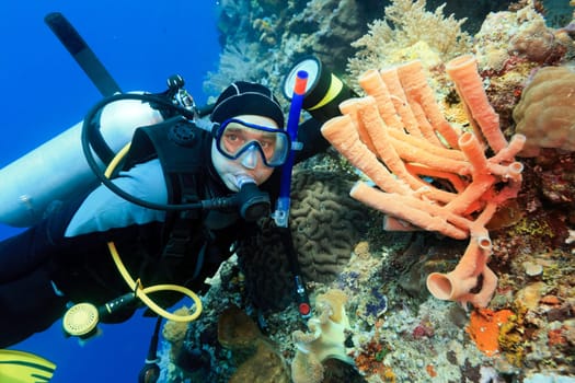 Scuba diver underwater close to coral reef