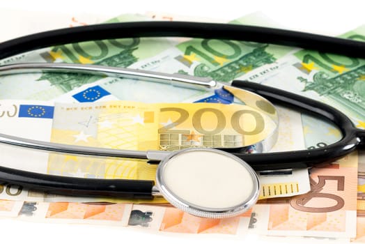 Stethoscope with banknotes against white background