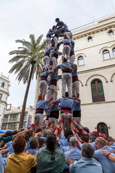 BARCELONA - NOVEMBER 18: Some unidentified people called Castellers do a Castell or Human Tower, typical tradition in Catalonia, on November 18, 2012 in Barcelona, Spain.