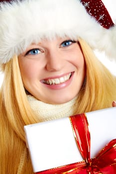 beautiful blonde woman holding a christmas gift is smiling