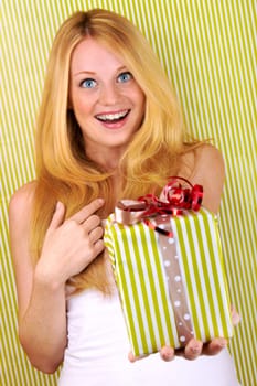 beautiful blonde woman holding a christmas gift is smiling