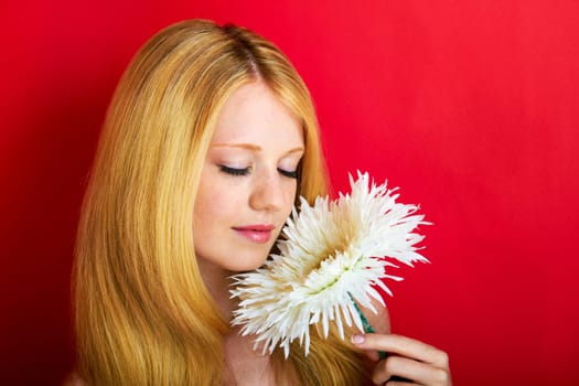 portrait of a young beautiful blonde girl with flower