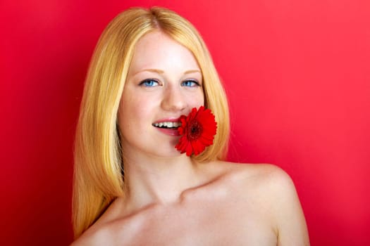 portrait of a young beautiful blonde girl with flower